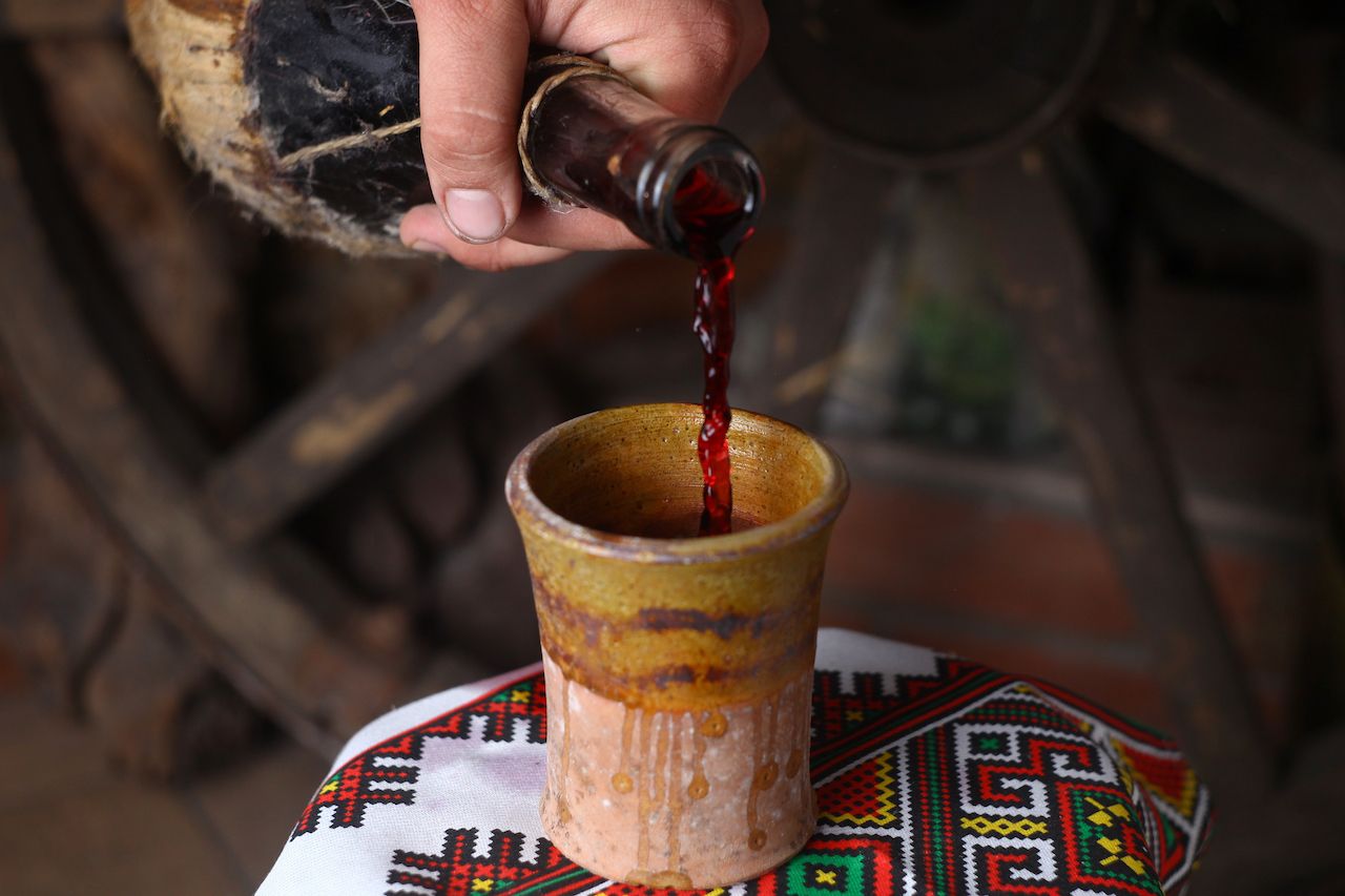 Homemade Moldovan wine pouring from a traditional homemade bottle