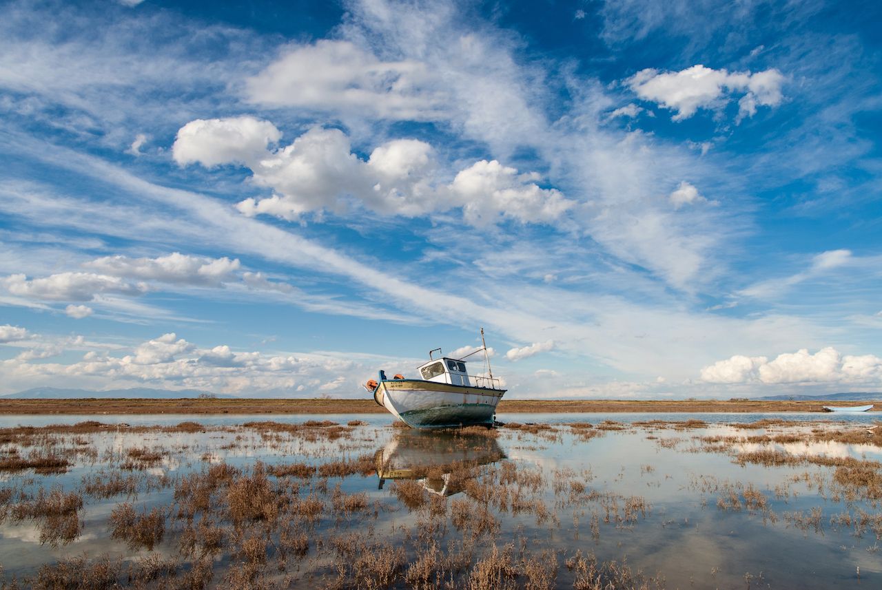 Landscape with traditional wooden boat in Axios Delta near Thessaloniki, Greece